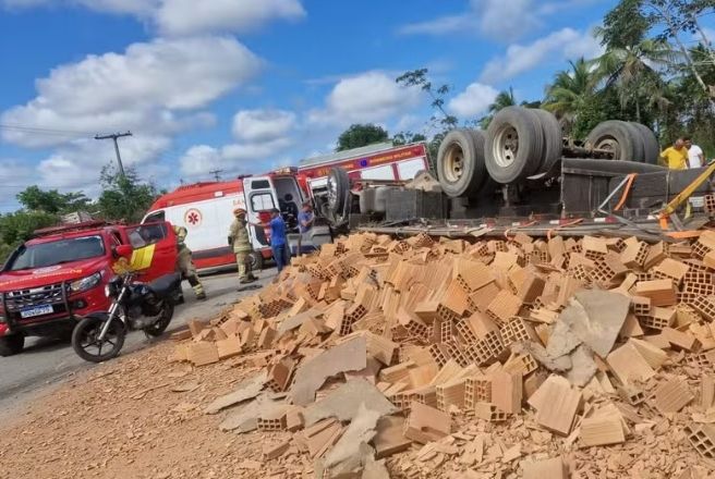 Motorista fica ferido após caminhão carregado de tijolos capotar