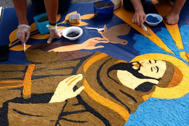 Fiéis enfrentam chuva para fazer tapetes de Corpus Christi